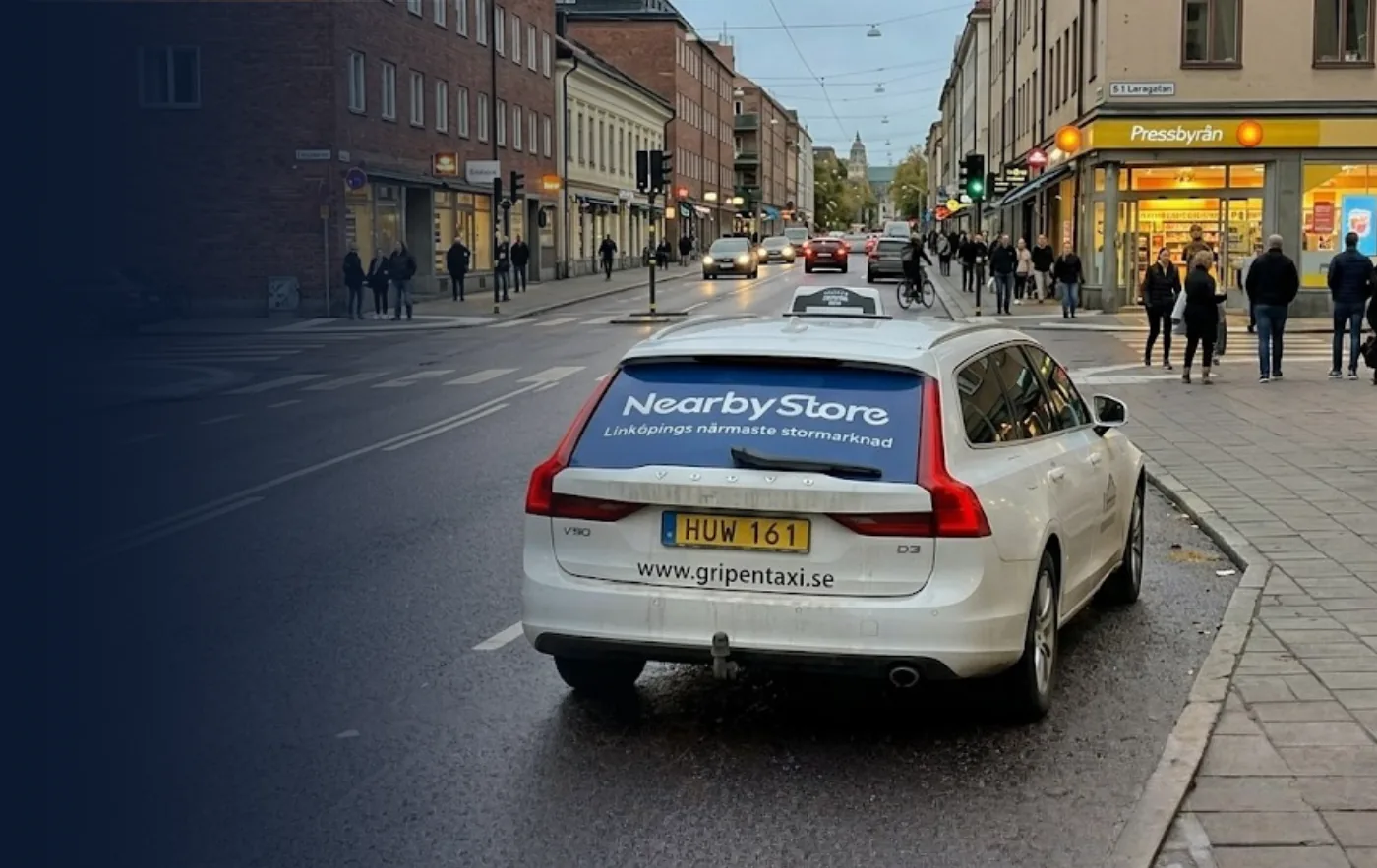Taxi med bakrutereklam i trafiken i Linköping